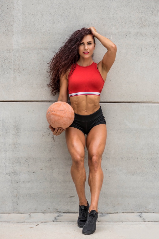 Aniko as a competitive fitness athlete, holding a basketball